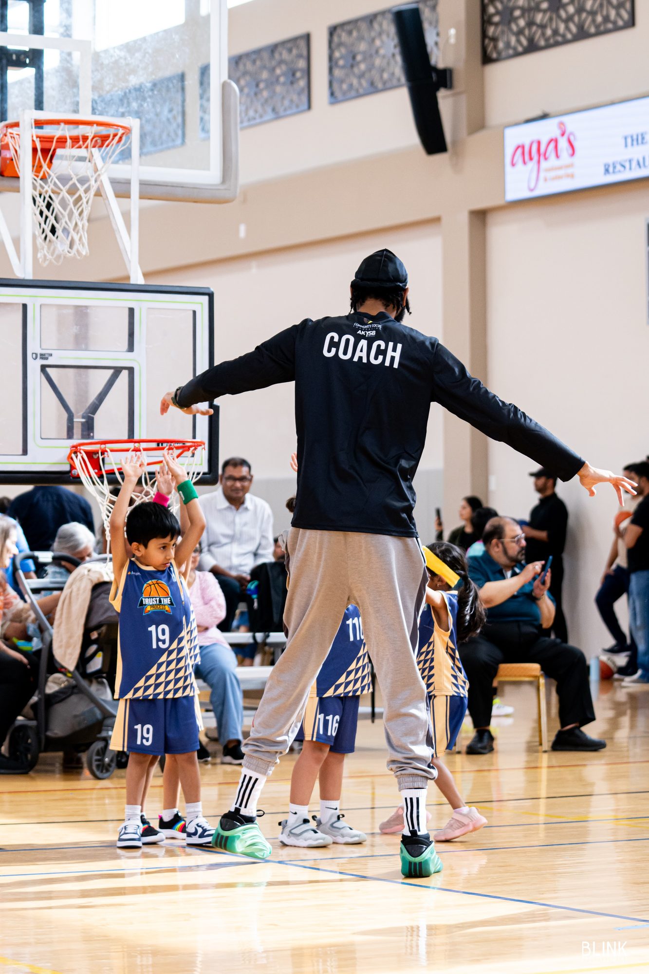 A coach gathers Trust the Process players under the hoop