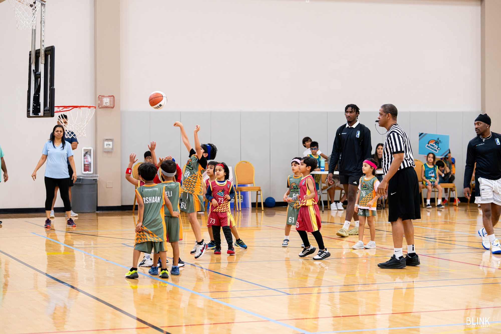 A Green Giants player puts up a shot while the referee watches