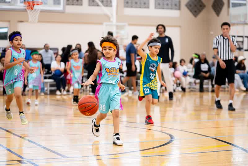 A young player dribbles up the floor while teammates run with him